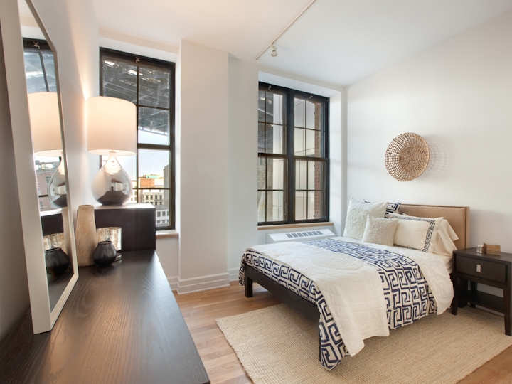 a bedroom with a bed and a chair in a room