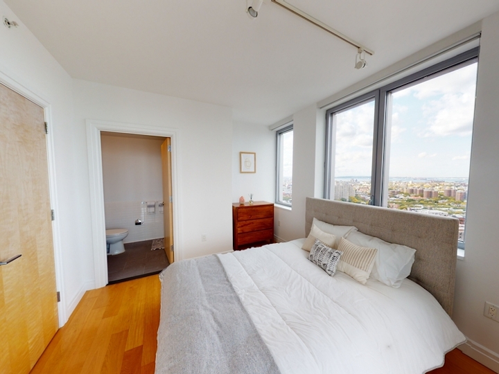a bedroom with a bed and a large window