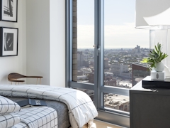 Thumbnail of The Ashland: 39J a view of a living room filled with furniture and a large window