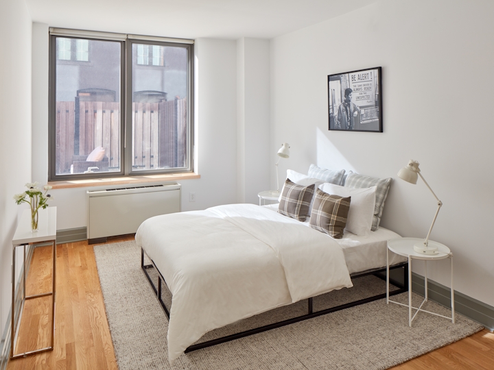 a bedroom with a bed and a chair in a room