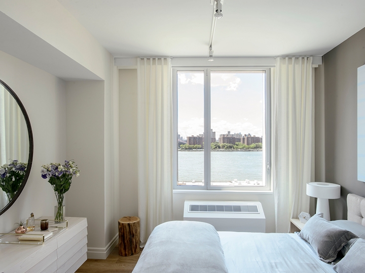 a bedroom with a bed and a large window