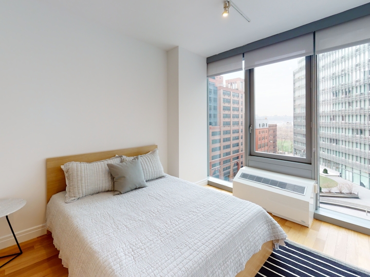 a bedroom with a bed and desk in a room
