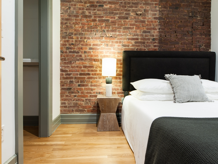 a bedroom with a bed and a chair in a room