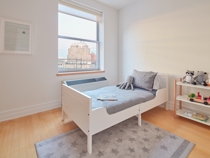 a bedroom with a bed and desk in a room