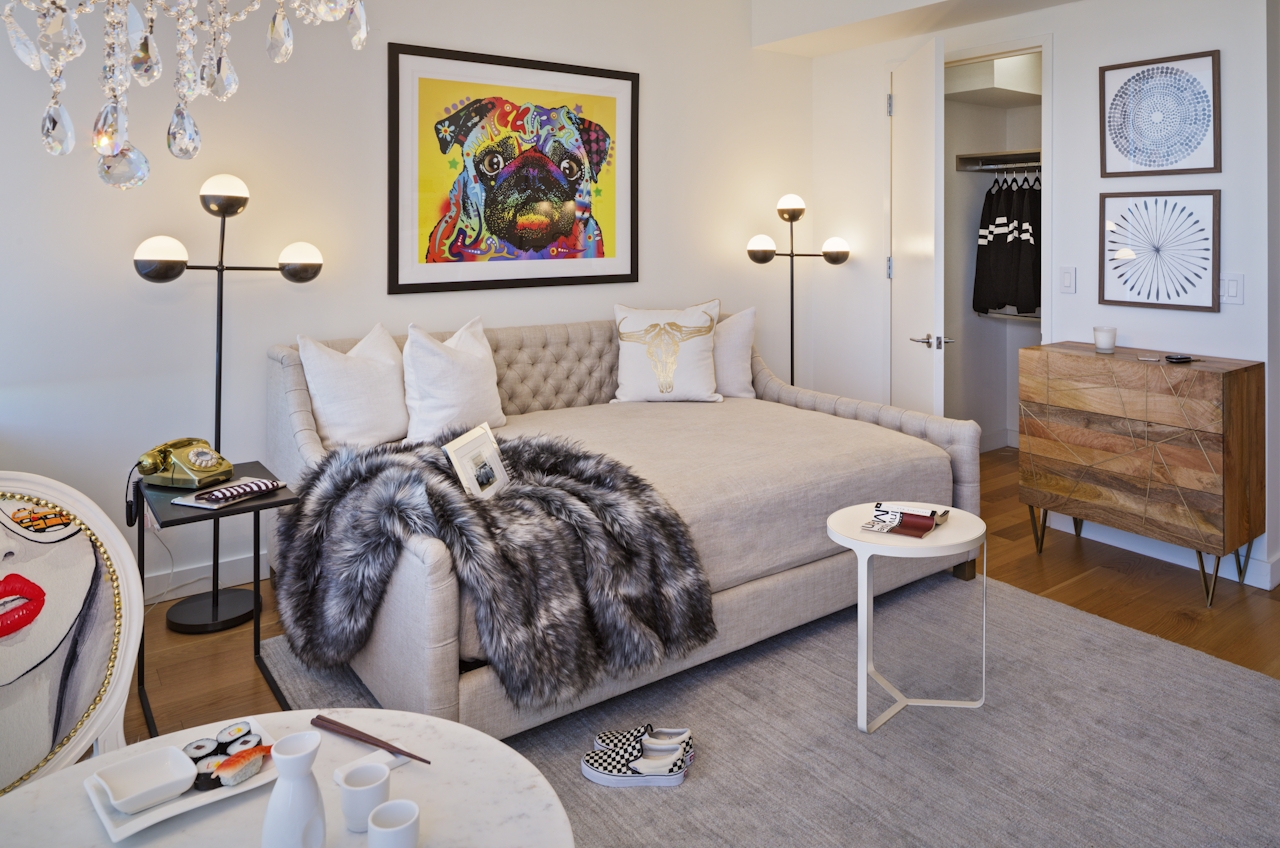 a bedroom with a cat on a table