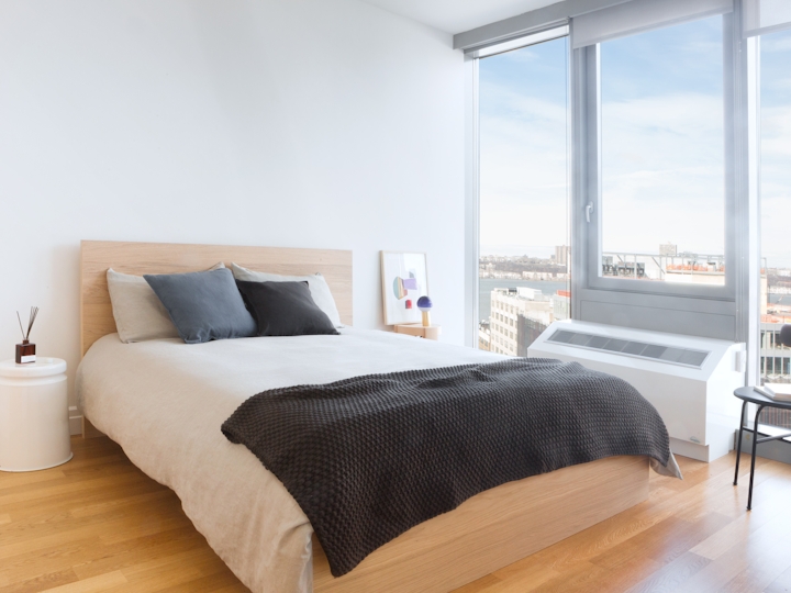 a bedroom with a bed and a chair in front of a window