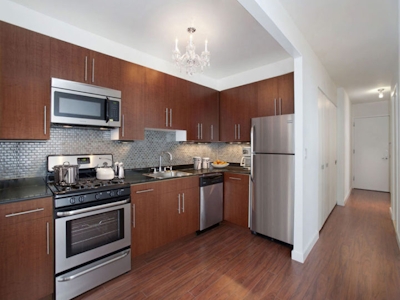 a large kitchen with stainless steel appliances and wooden cabinets