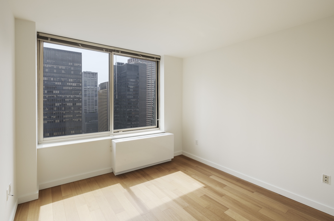 a room with white walls and a large window