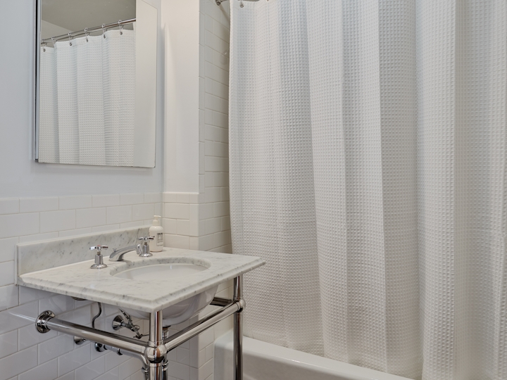a white sink sitting next to a shower curtain