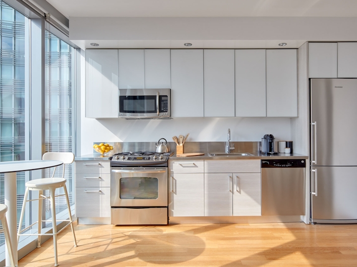 a modern kitchen with stainless steel appliances and wooden cabinets