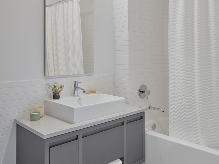 a white sink sitting under a mirror
