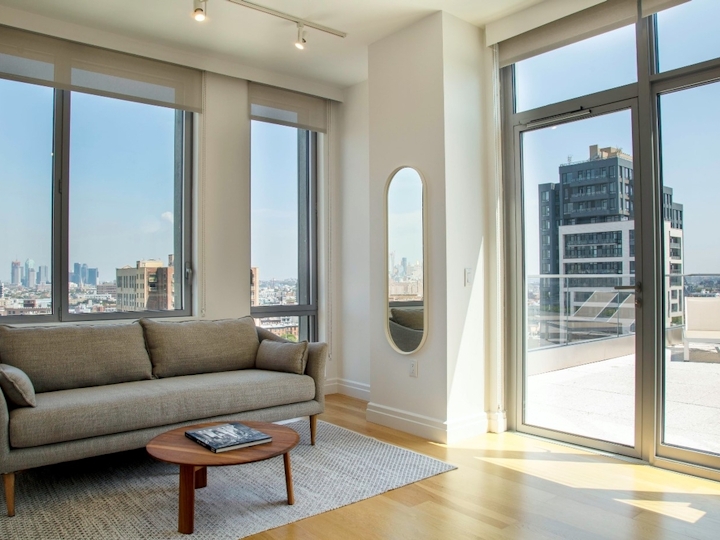 a view of a living room filled with furniture and a large window