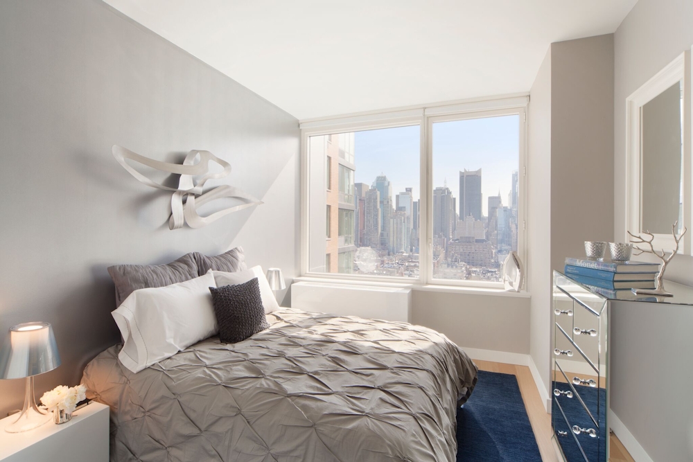 Gotham West: 2717 a bedroom with a bed and desk in a room