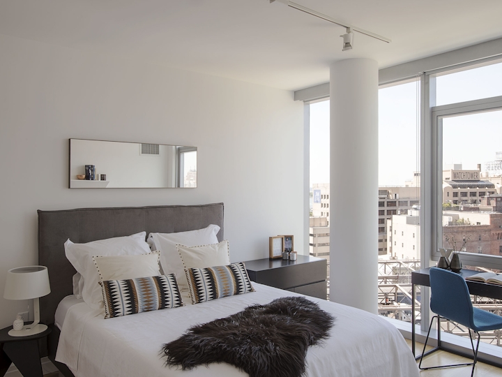 a bedroom with a bed and a chair in a room