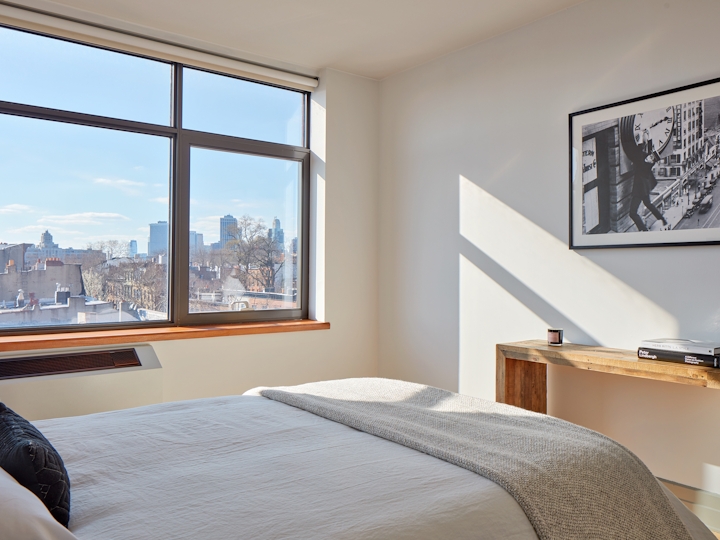 a bedroom with a bed and a large window
