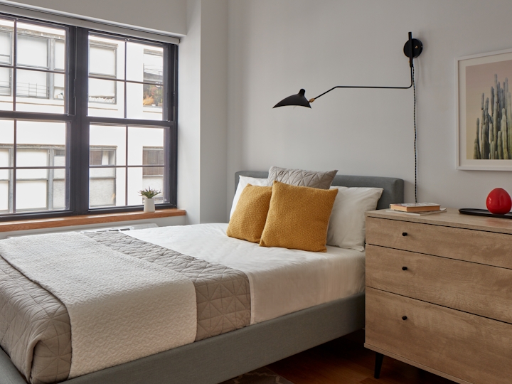 a bedroom with a bed and desk in a room