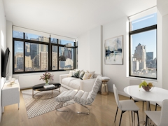 Thumbnail of The Nicole: 3E a living room filled with furniture and a large window