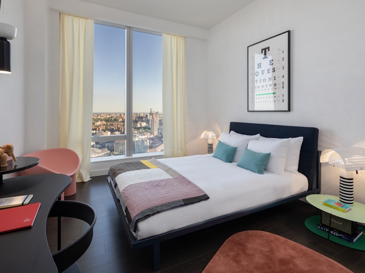 a bedroom with a bed and desk in a room