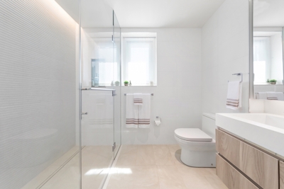 a white sink sitting under a window next to a shower
