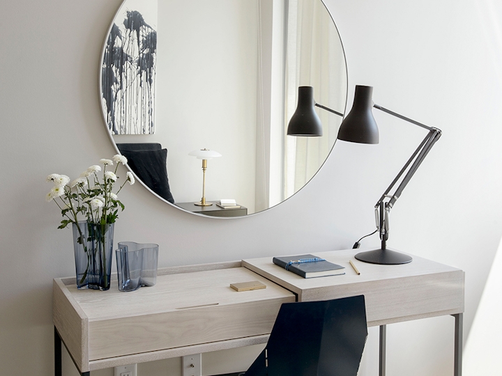 a desk with a computer and a chair in a room