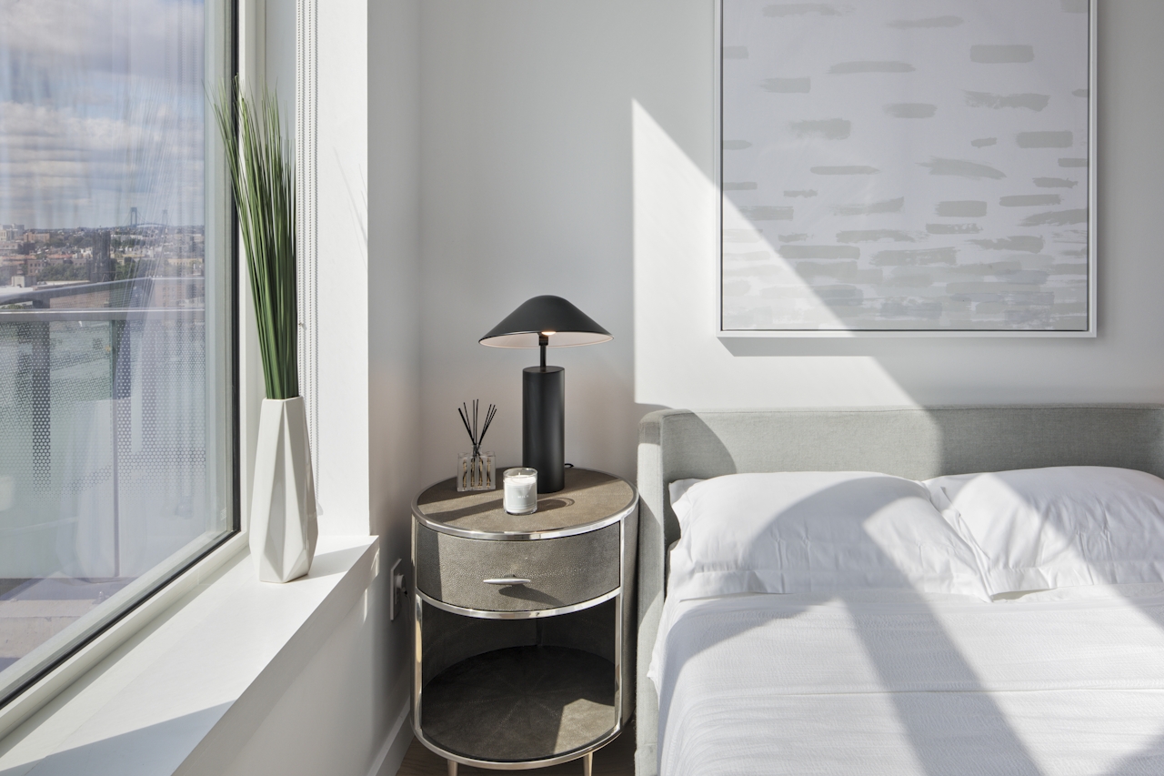 a large white bed sitting next to a window