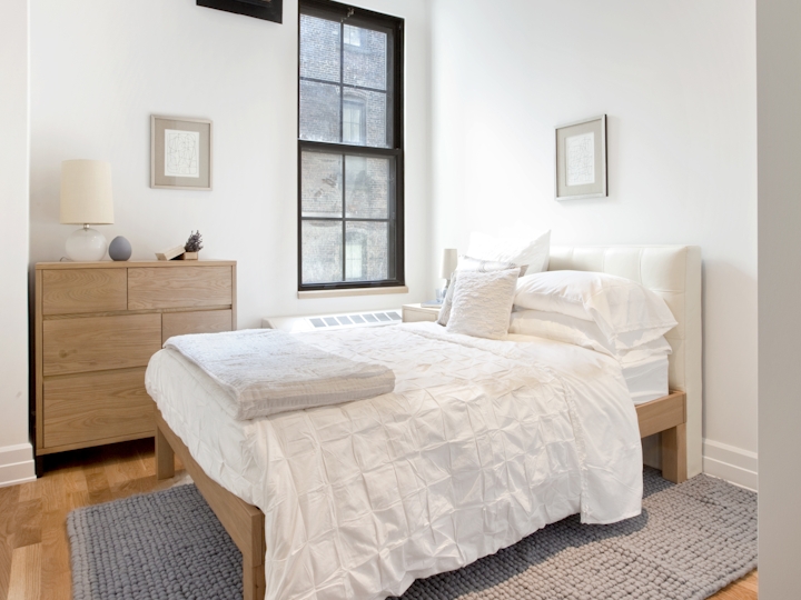 a bedroom with a bed and desk in a room