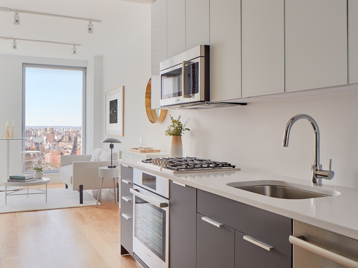 a kitchen with a sink and a mirror in a room