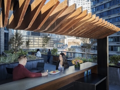 Thumbnail of The Ashland: PH2A a group of people sitting at a table in front of a building