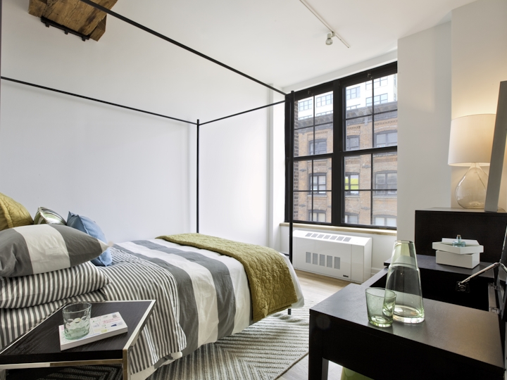 a bedroom with a bed and desk in a room