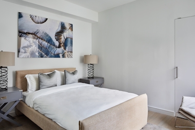 a bedroom with a bed and a chair in a room