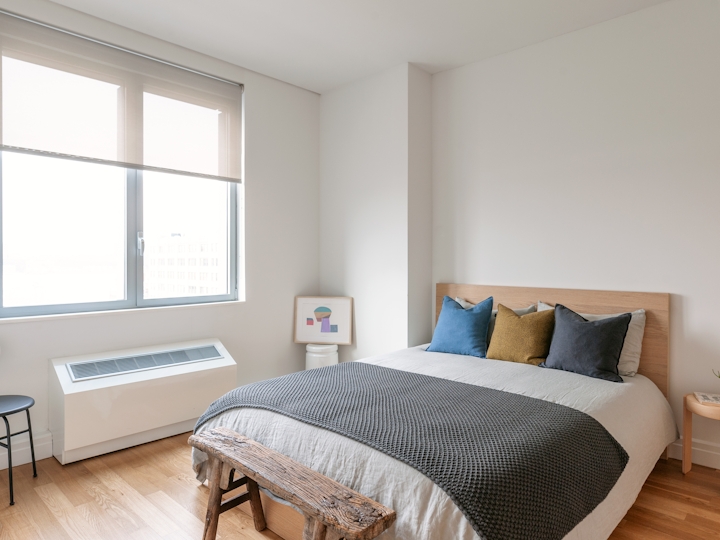 a bedroom with a bed and a chair in a room
