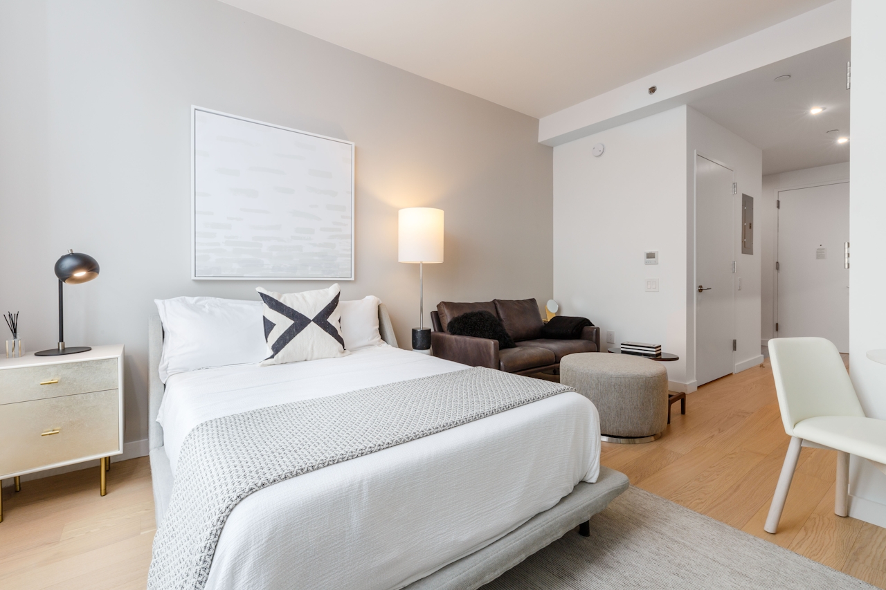 a bedroom with a bed and a chair in a room