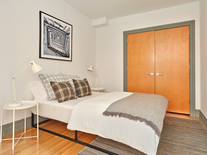 a bedroom with a bed and a chair in a room