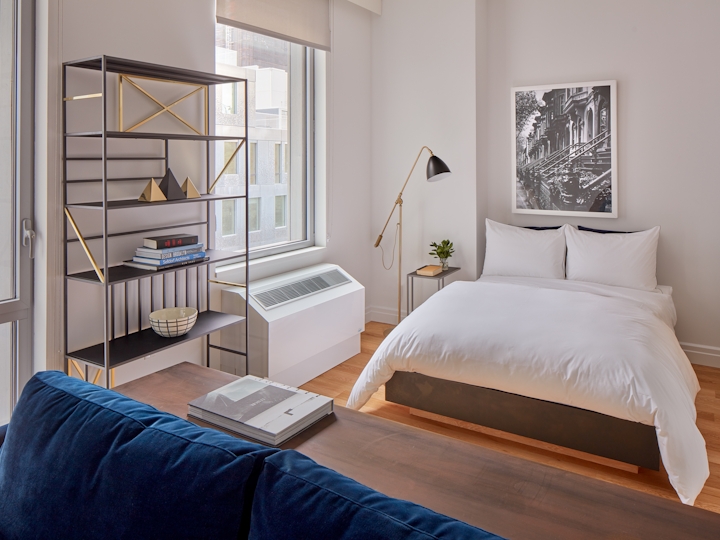 a bedroom with a bed and desk in a room