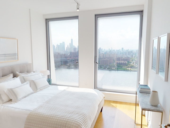 a bedroom with a bed and a large window