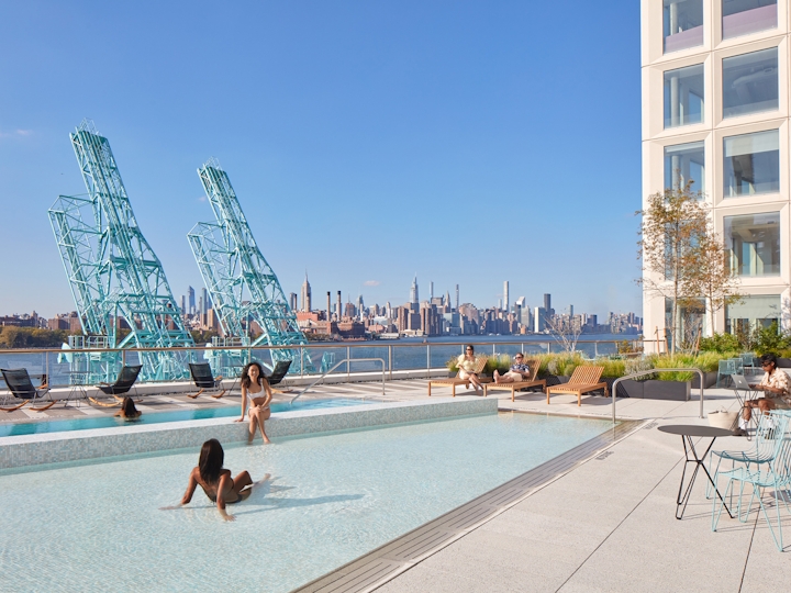 a group of people on a beach with a city in the background