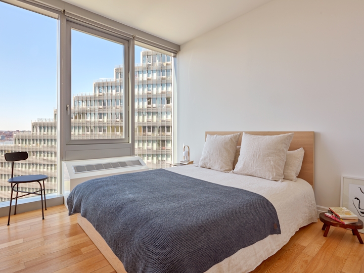 a bedroom with a bed and a chair in a room