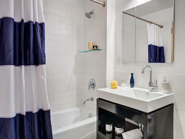 a white sink sitting next to a shower curtain