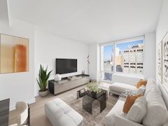 Thumbnail of Gotham West: 2717 a living room filled with furniture and vase of flowers on a table