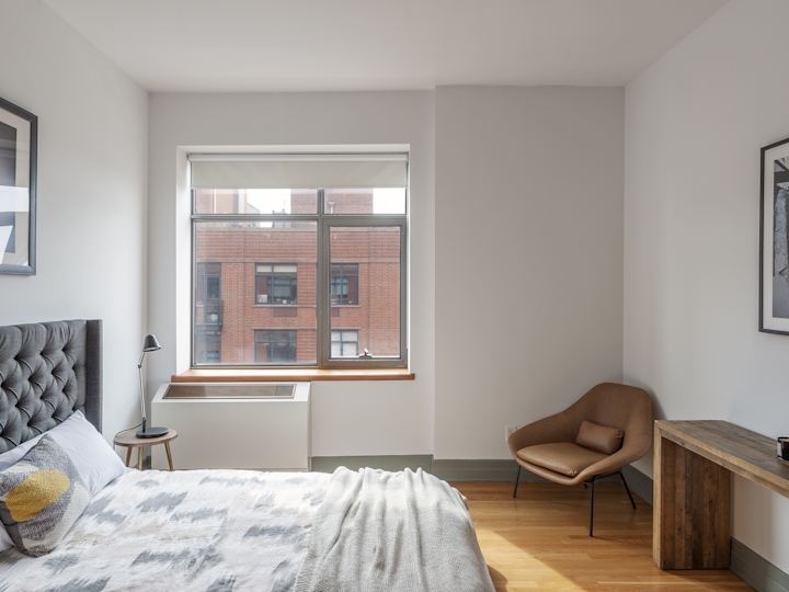 a bedroom with a bed and a mirror in a room