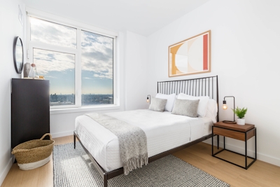 a bedroom with a bed and a chair in a room