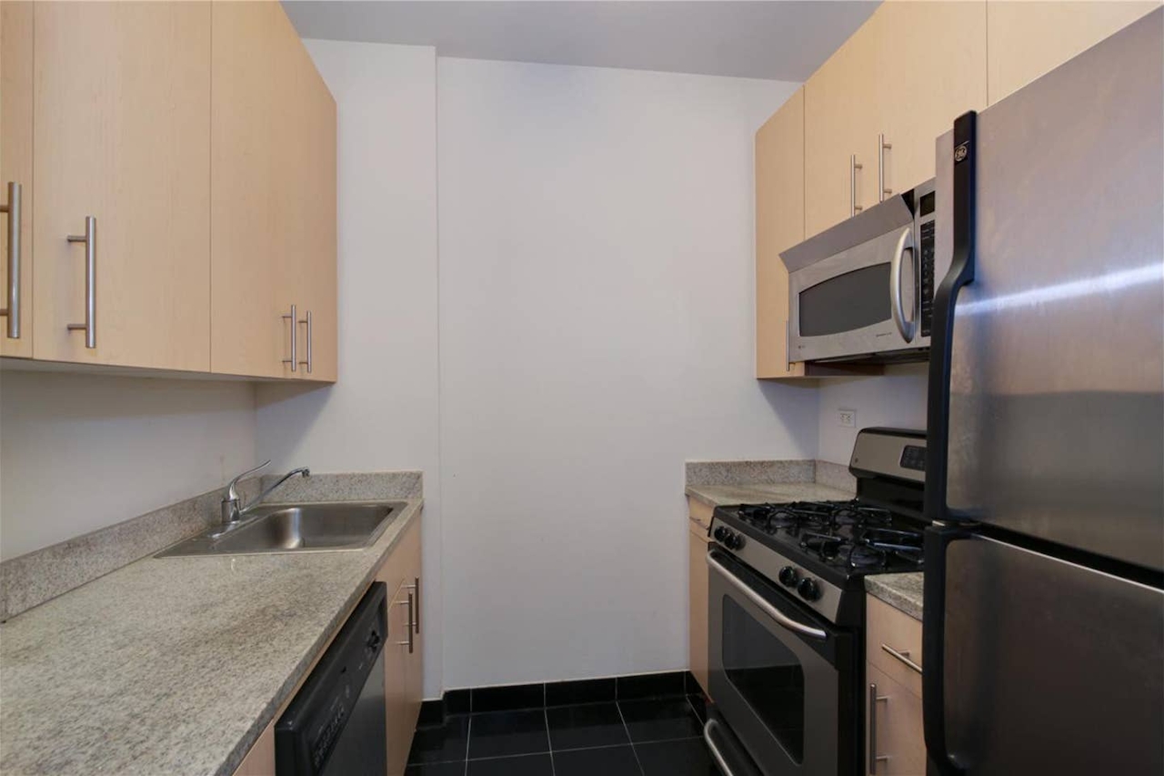 a stove top oven sitting inside of a kitchen with stainless steel appliances