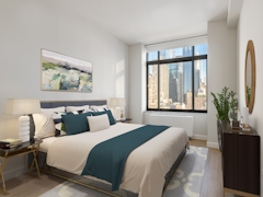 Thumbnail of The Nicole: 3E a bedroom with a large bed in a room