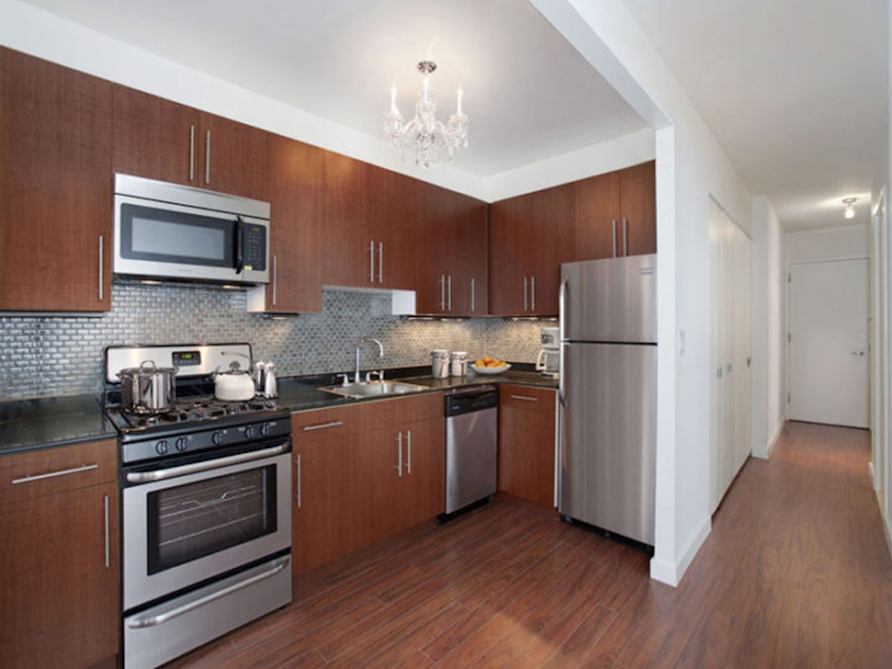 a large kitchen with stainless steel appliances and wooden cabinets