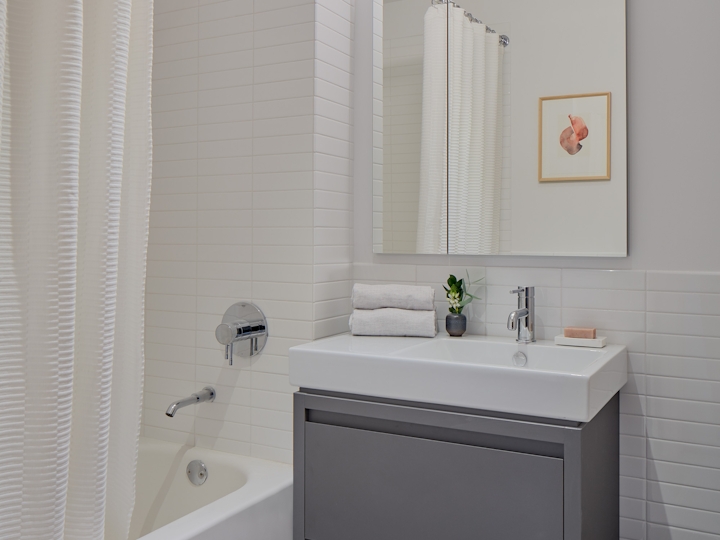 a white sink sitting under a mirror