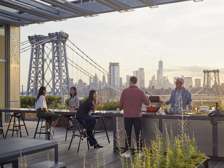 a group of people sitting at a table with a bridge in the background