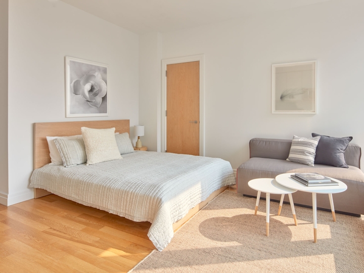 a bedroom with a bed and a chair in a room