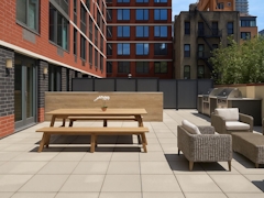 Thumbnail of The Nicole: 5C a bench in front of a brick building