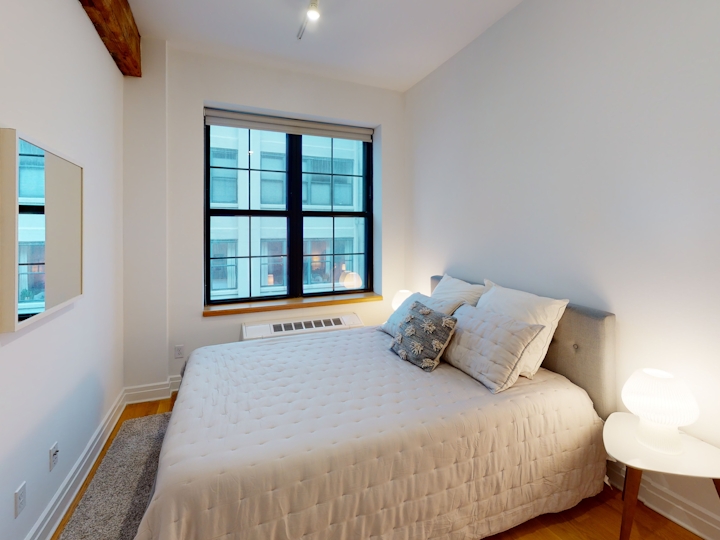 a bedroom with a bed and window in a room