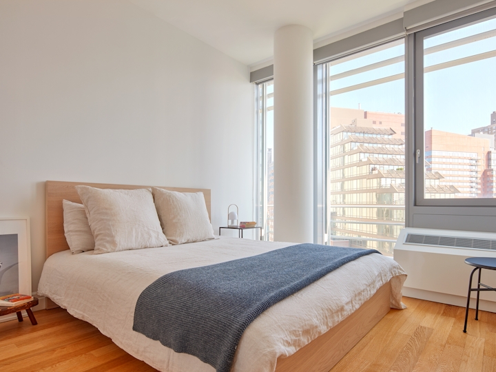 a bedroom with a bed and desk in a hotel room